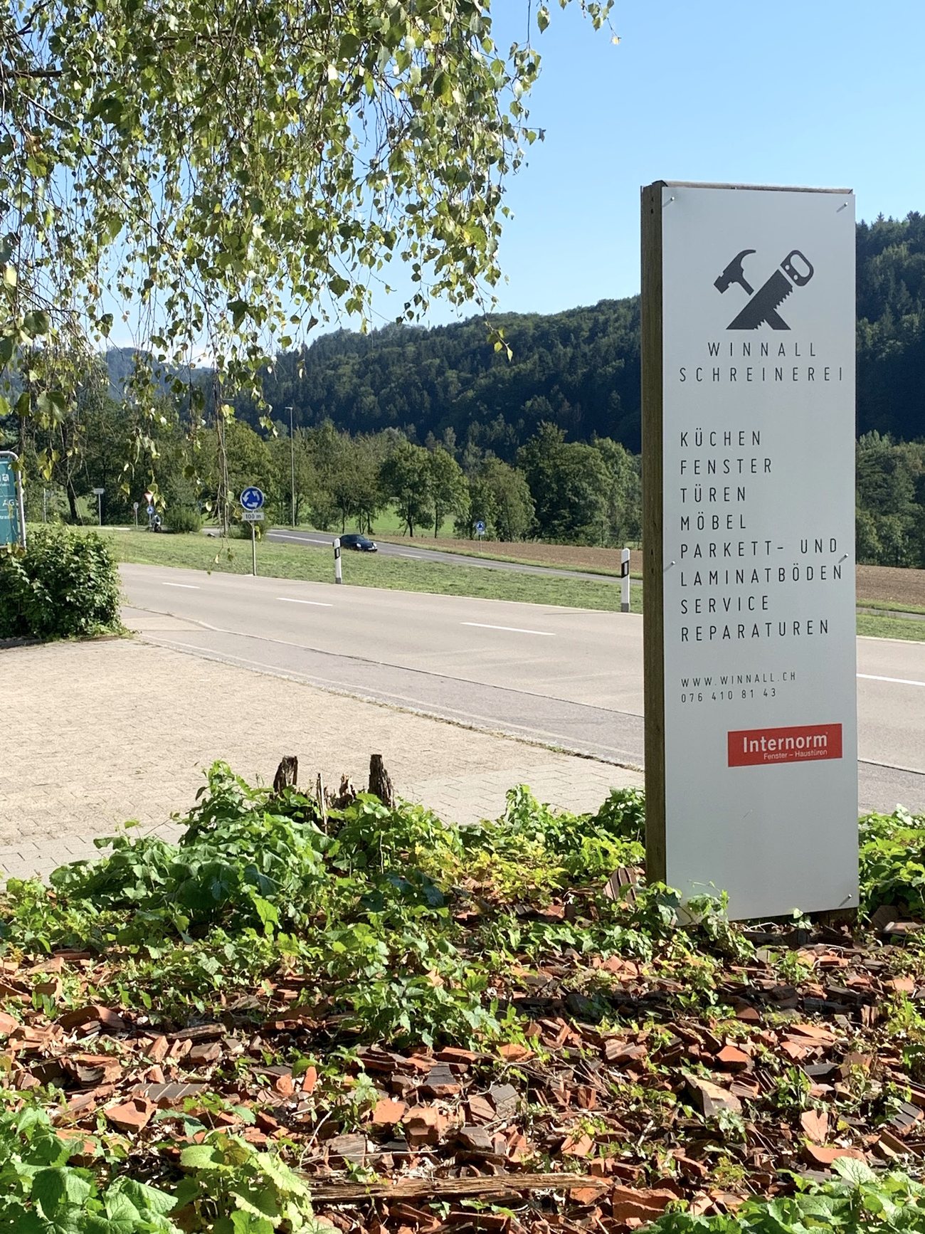 Freistehende Hinweistafel der Winnall Schreinerei mit Leistungsliste