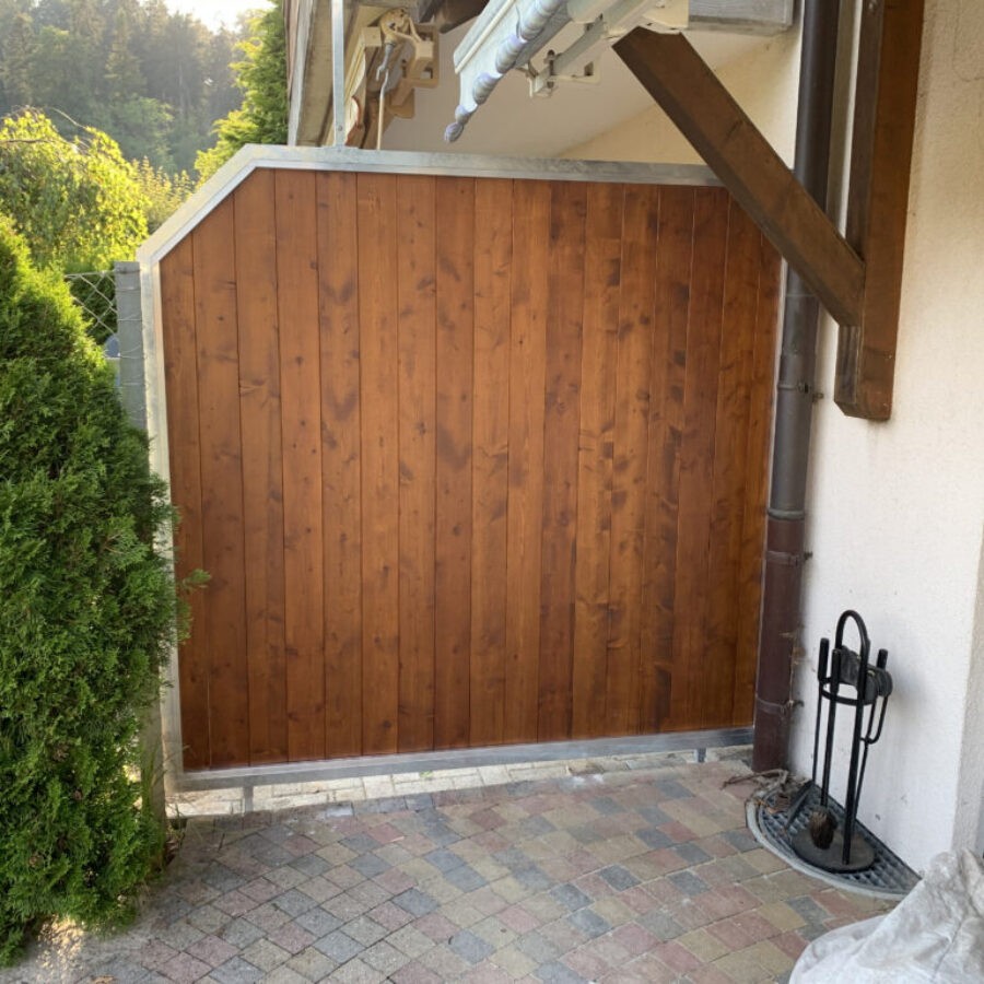Sichtschutzwand aus braunen Holzbrettern an einer Hauswand