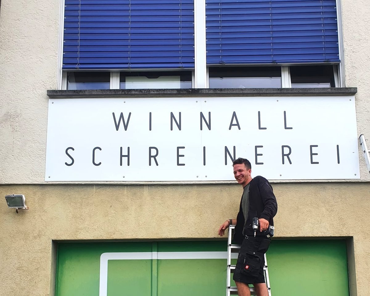 Am Schriftzug der Winnall Schreinerei vor der Werkstatt